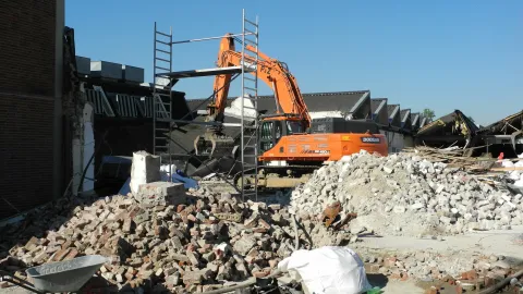 Ein Bagger reißt Mauern nieder