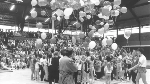 Große Gruppe von Menschen, die Luftballons steigen lässt